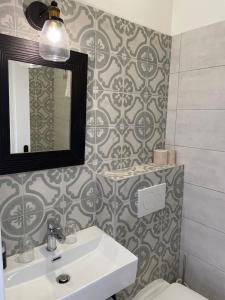 a bathroom with a sink and a mirror and a toilet at Hôtel La Villa Patricia - Charme et Tradition in Villefranche-sur-Mer