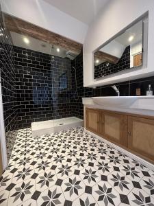 a bathroom with a black and white tile floor and a tub at The Beeches - Chatsworth Apartment No 5 - Sleep2 in Baslow