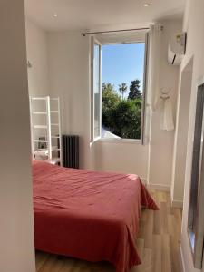 a bedroom with a red bed and a window at Hôtel La Villa Patricia - Charme et Tradition in Villefranche-sur-Mer
