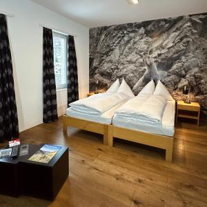a bedroom with a bed with a painting on the wall at Hotel Rätia in Ilanz