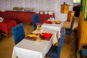 a dining room with two tables and blue chairs at Amanya Sleeps 4 with Tent Views in Amboseli