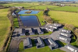 an aerial view of a house with a lake at Arranview Lochside Pods & Lodges all with private Hot-tubs in Fenwick