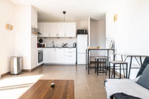 cocina y sala de estar con sofá y mesa en La Parenthèse - Annecy- Grande Terrasse - Chambre - Garage, en Annecy