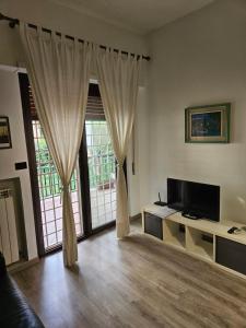 uma sala de estar com televisão e uma grande janela em ROME HOLIDAY QUIET AND CONFORTABLE APARTMENT em Roma