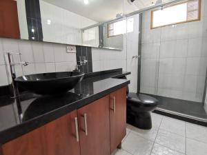 通哈的住宿－aparta estudio independiente centro Tunja，一间带黑色水槽和卫生间的浴室