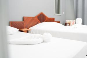 2 camas con toallas blancas encima en L'Hôtel Du Fleuve en Sinnamary