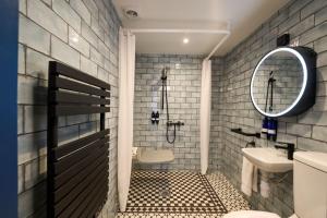 een badkamer met een wastafel, een toilet en een spiegel bij Plockton Inn in Plockton