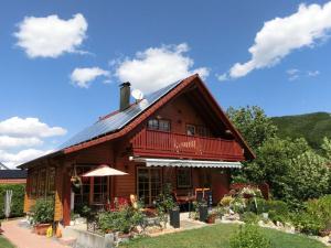 a wooden house with a red roof at Holiday apartment Sterrenbergblick in Oberlenningen