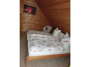 a bedroom with a bed in a wooden cabin at Holiday apartment Sterrenbergblick in Oberlenningen