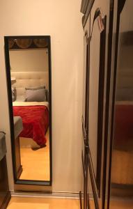 einen Spiegel vor einem Schlafzimmer mit einem Bett in der Unterkunft Quarto no centro d Lisboa in Lissabon