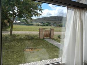 a window view of a yard with a gate at Lafiaca in Sierra de la Ventana +23 photos