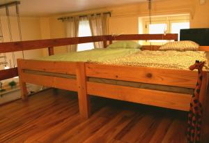 a large wooden bed in a room with wooden floors at LEM Family Apartment in Budapest