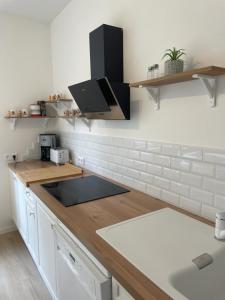 une cuisine avec des armoires blanches et un comptoir dans l'établissement Triplex - 4 chambres - Centre historique, à Bourges 9 autres photos