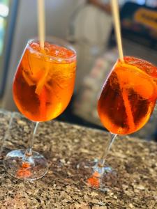 due bicchieri di cocktail arancioni seduti su un bancone di hotel iris a Rimini