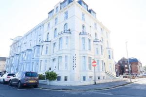 a white building with cars parked in front of it at Farina No6, Sea view apartment sleeping 4 guests in Bridlington