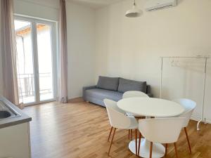 a living room with a table and chairs and a couch at Bocconi Navigli-La casa di Zoe in Milan