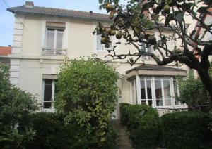 Una casa blanca con un árbol delante. en Lofoten, en Le Touquet-Paris-Plage