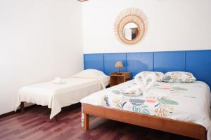 2 Betten in einem Zimmer mit blauen und weißen Wänden in der Unterkunft L'Hôtel Du Fleuve in Sinnamary + 37 Fotos