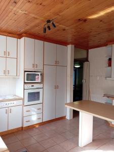 cocina con armarios blancos y techo de madera en Beyond New House, en Ciudad del Cabo