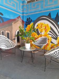 2 sillas y una mesa frente a un mural en hotel nativo en Valledupar