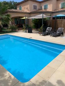 une piscine bleue devant une maison dans l'établissement Villa paradis, à Fréjus 2 autres photos
