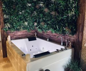 una bañera con una pared verde detrás. en Suite romantique avec sauna et jacuzzi, 