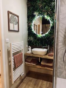 baño con espejo grande y lavabo en Suite romantique avec sauna et jacuzzi, 