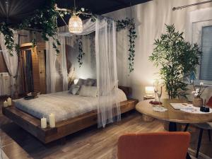 En eller flere senge i et værelse på Suite romantique avec sauna et jacuzzi