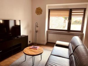 a living room with a couch and a coffee table at Appartement en centre-ville in Saint-Avold