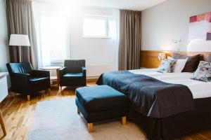 een hotelkamer met 2 bedden en 2 stoelen bij Best Western Valhall Park Hotell in Ängelholm