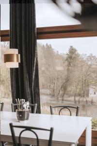un tavolo bianco con sedie di fronte a una finestra di Villa Madona a Tellin