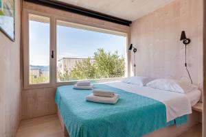 a bedroom with a bed with two towels on it at BUQEZ ECO RESORT - Beach Villa 12 - Nice view in Drage
