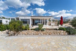 a house with a stone wall in front of it at BUQEZ ECO RESORT - Beach Villa 12 - Nice view in Drage