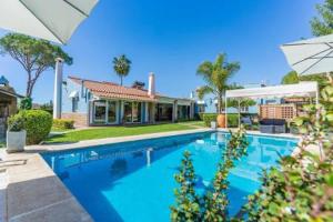 a swimming pool in front of a house at Casa Golf Azul - Suite Viagens in Aljaraque