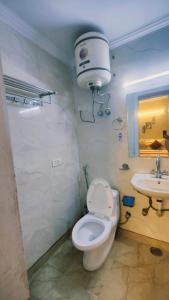 a bathroom with a white toilet and a sink at Royal galaxy kalkaj in New Delhi