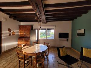 eine Küche und ein Esszimmer mit Tisch und Stühlen in der Unterkunft Au repos du pêcheur in Bouchamps-lès-Craon