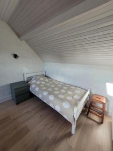 ein Schlafzimmer mit einem Bett und einem Holzboden in der Unterkunft Au repos du pêcheur in Bouchamps-lès-Craon