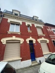 a red brick building with a blue door at La grande Amiénoise de 7 chambres, quartier calme et résidentiel in Amiens