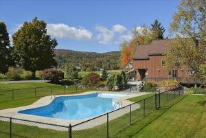 uma piscina num quintal ao lado de uma casa em Stonybrook 79 em Stowe