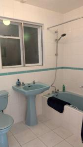 a bathroom with a sink and a toilet and a tub at Secluded self-contained Annexe near town centre in St Austell
