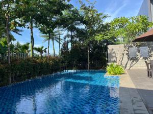 a swimming pool in a yard with trees at 2 Floor Cozy House in Wisteria Jakarta Garden City in Jakarta