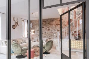 una stanza con porte in vetro e una parete in pietra di Villa Madona a Tellin