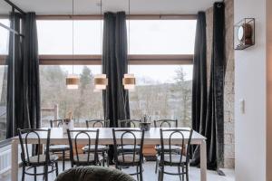 una sala da pranzo con tavolo, sedie e una grande finestra di Villa Madona a Tellin