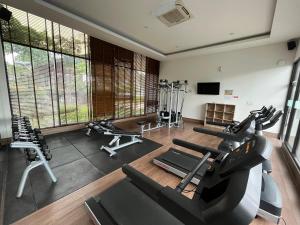 a gym with treadmills and exercise bikes in it at 2 Floor Cozy House in Wisteria Jakarta Garden City in Jakarta