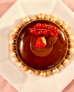un dessert au chocolat avec une fraise sur une assiette dans l'établissement Aux bonheurs des roses, à Valmont