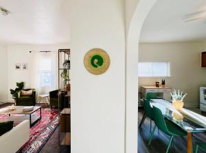 a living room with a table and green chairs at Botanical Bungalow in Greensburg in Greensburg