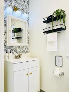 a bathroom with a sink and a mirror at Botanical Bungalow in Greensburg in Greensburg