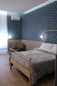 1 dormitorio con cama y pared azul en Palazzo Ferrara en Nápoles