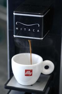 Una cafetera está vertiendo café en una taza de café en Palazzo Ferrara, en Nápoles