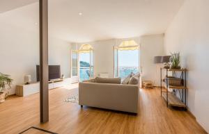 a living room with a couch and a television at Les Pieds Dans L'Eau - Bel appartement - Vue mer in Cancale